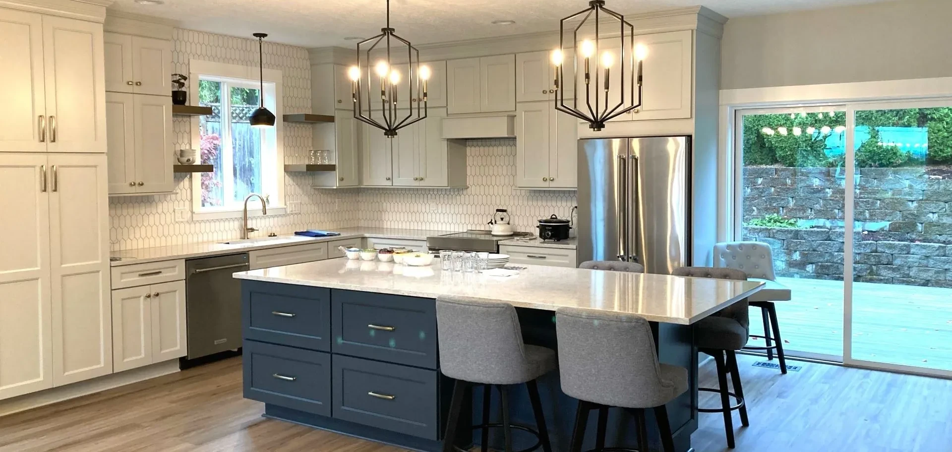 Custom kitchen remodel with large island seating, white cabinetry, hex tile backsplash, and pendant lighting in Portland home