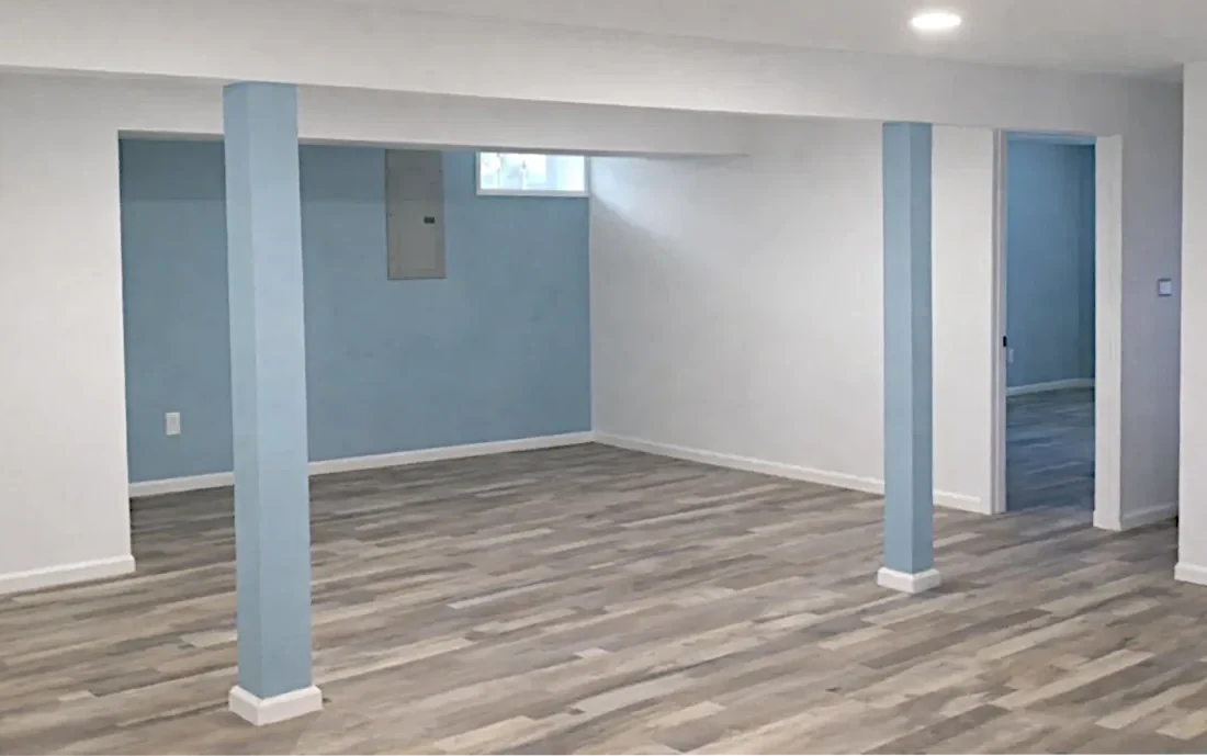 Basement remodel with open living space and support columns in NE Portland home