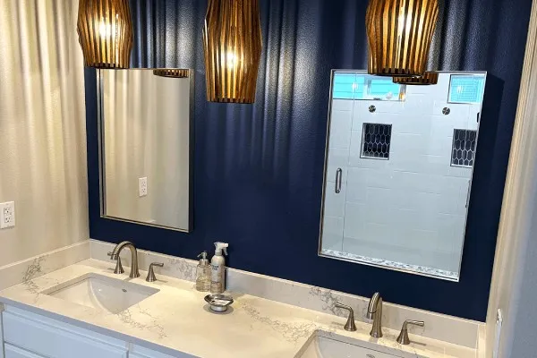 Bathroom remodel featuring double vanity, blue wall, and modern lighting in Portland home