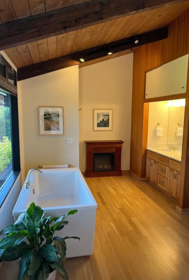 Bathroom remodel with freestanding tub, wood beams, and fireplace in a Southwest Hills Portland home