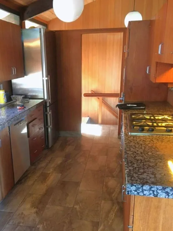 Original range area before the Southwest Hills kitchen remodel, with older cabinetry, counters, appliances, and finishes.