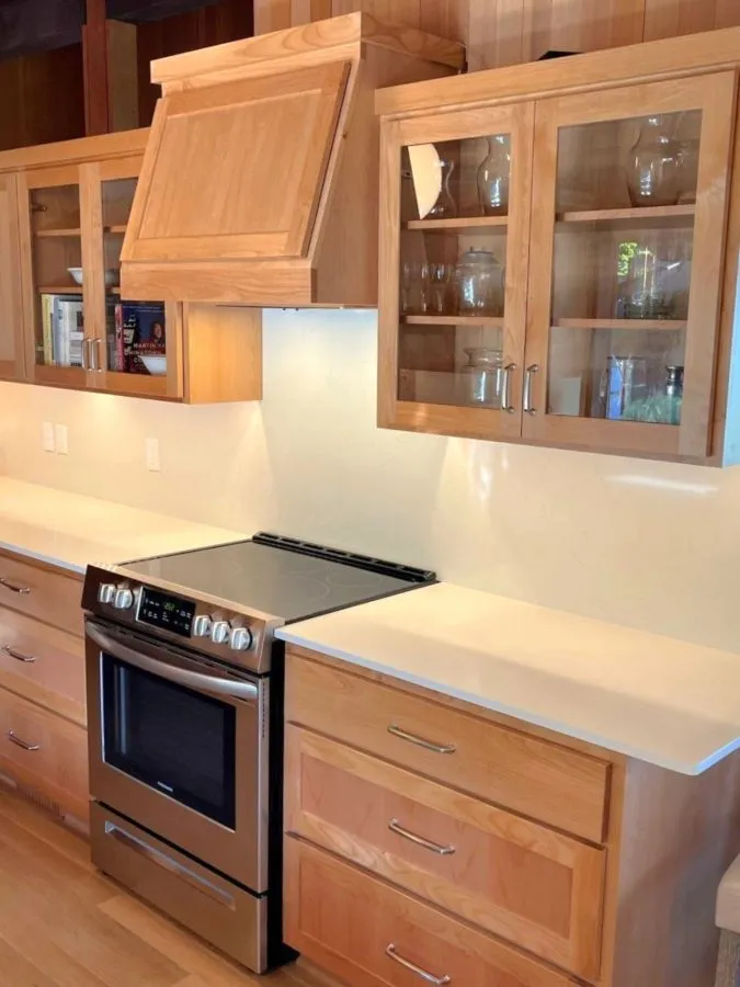 Close-up of custom wood cabinetry, quartz countertops, and built-in range area in a Southwest Hills kitchen remodel in Portland.