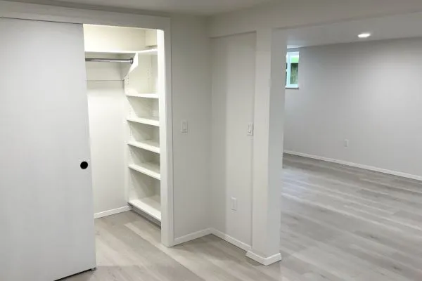Basement remodel with flexible living area and built-in shelving in Portland home