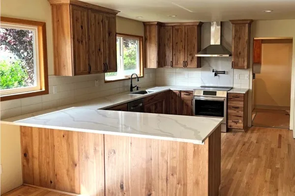 Kitchen remodel with natural wood cabinets and peninsula layout in Portland, Oregon home.