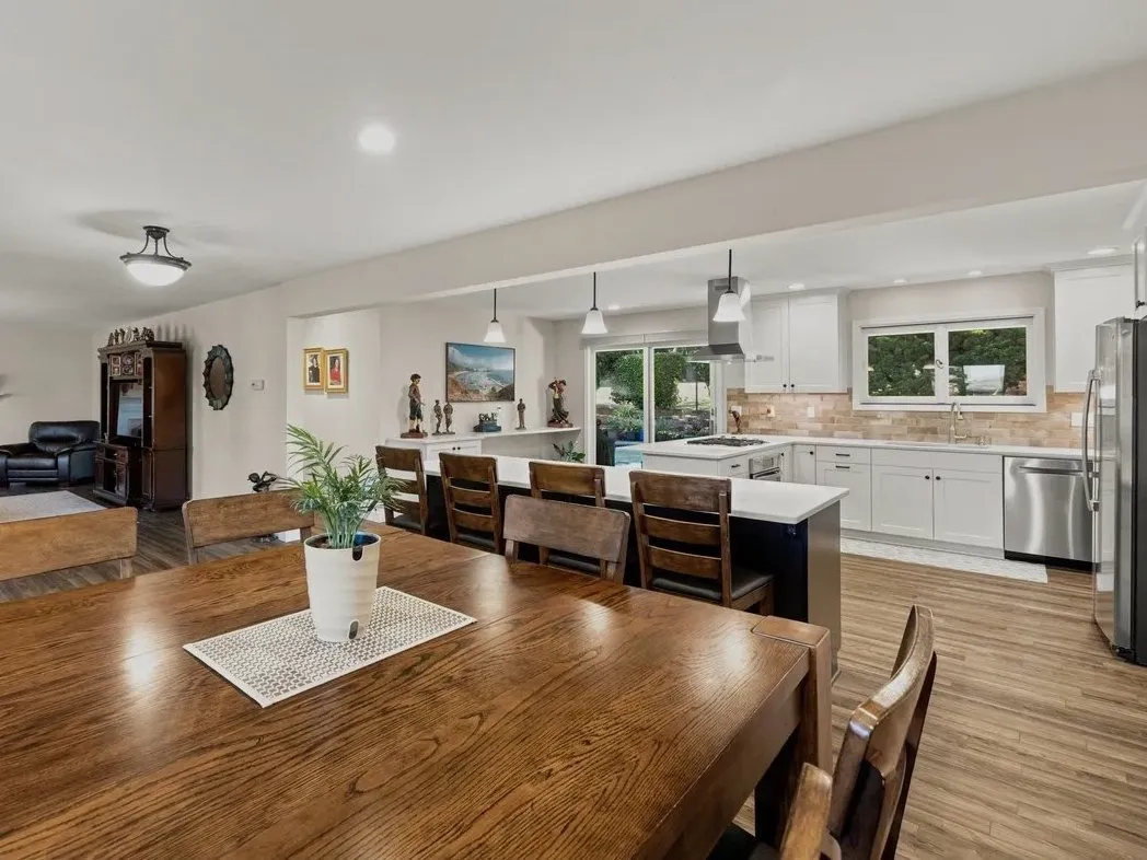 Open dining area, living room, and remodeled kitchen with continuous new flooring