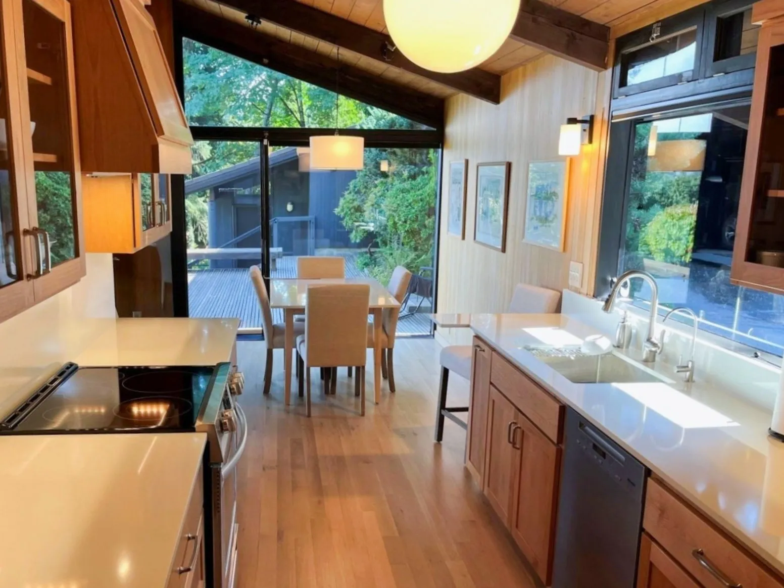 Kitchen remodel in Portland&rsquo;s Southwest Hills with custom cabinetry, quartz countertops, and vaulted wood ceiling overlooking dining area and deck.