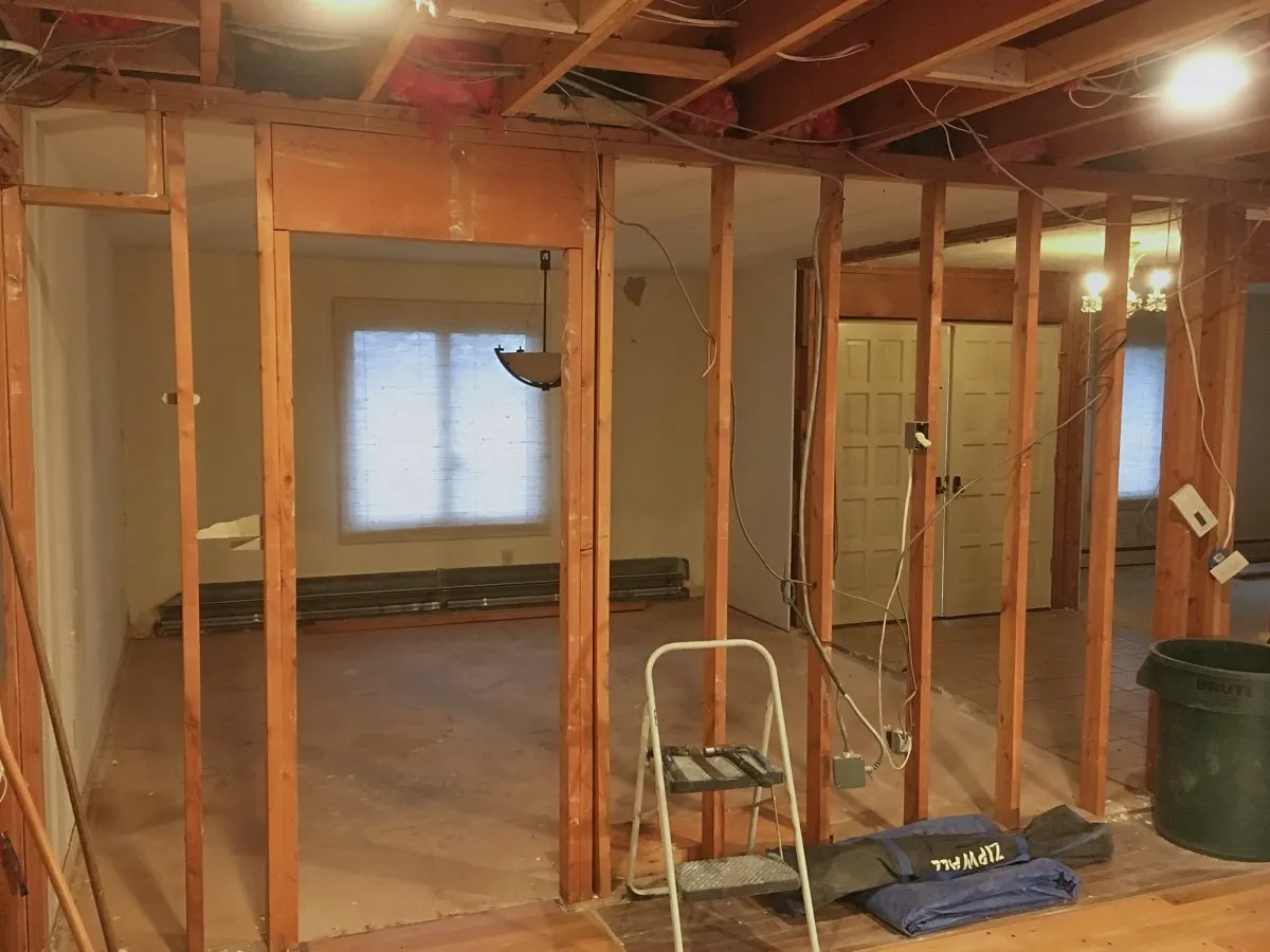 Exposed wall framing during removal of walls between the foyer, living room, dining room, and kitchen