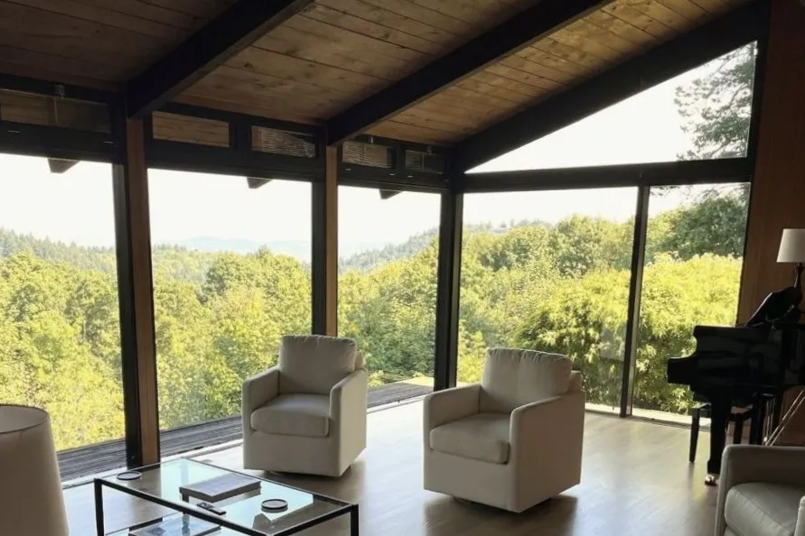 Whole home renovation with open living room, wood beams, and large windows in southwest Portland home.
